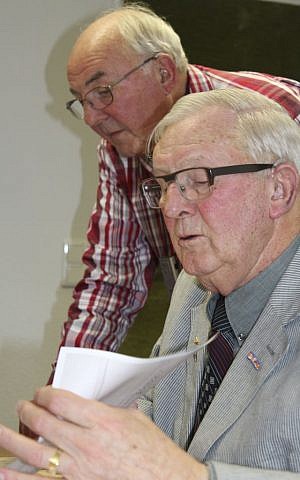 In this photo provided by International Tracing Service (ITS), Joop and Peter Will, sons of late Dutch resistance fighter Peter Will, look through family memorabilia including a farewell letter to his family when he was seized by the Nazis in 1943 and shipped off to Neuengamme concentration camp. (ITS via AP) 