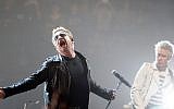 Bono, left, and Adam Clayton of U2 perform on stage during a concert, in Paris, Sunday, Dec. 6, 2015. U2’s performance in Paris on Sunday night wasn’t just about music _ it had a mournful tinge, too. Frontman Bono paid respects to 130 people killed by terrorists in Paris on Nov. 13, and 14 people killed in a mass shooting last week in California. (AP Photo/Thibault Camus)