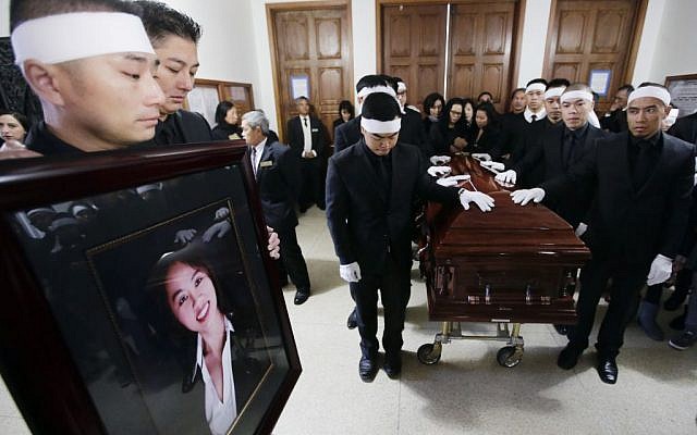 San Trinh, left, holds a portrait of his fiance Tin Nguyen at her funeral on Saturday, Dec. 12, 2015 in Santa Ana, Calif. Nguyen died in the mass shootings in San Bernardino, Calif., Wednesday, Dec. 2. (AP Photo/Chris Carlson) San Trinh, left, holds a portrait of his fiance Tin Nguyen at her funeral on Saturday, Dec. 12, 2015 in Santa Ana, Calif. Nguyen died in the mass shootings in San Bernardino, Calif., Wednesday, Dec. 2. (AP Photo/Chris Carlson)