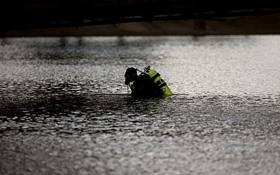 A member of the FBI dive team searches Seccombe Lake Friday, Dec. 11, 2015, in San Bernardino, Calif., for evidence in connection with last week's fatal shooting at Inland Regional Center. The FBI says divers are searching the lake because leads indicate the shooters who killed 14 people at a holiday party had been in the area. (AP Photo/Jae C. Hong)