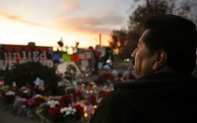 John Ramos, 58, of Riverside, California, pays his respects at a makeshift memorial site honoring Wednesday's shooting victims Monday, Dec. 7, 2015 in San Bernardino, California. (AP Photo/Jae C. Hong)