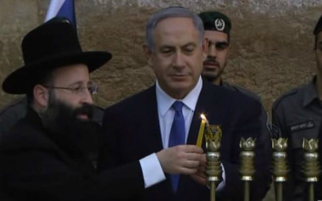 Prime Minister Benjamin Netanyahu joins Western Wall Rabbi Shmuel Rabinovitch to light the first night's Hanukkah candles, December 6, 2015. (YouTube screenshot) Prime Minister Benjamin Netanyahu joins Western Wall Rabbi Shmuel Rabinovitch to light the first night's Hanukkah candles, December 6, 2015. (YouTube screenshot)