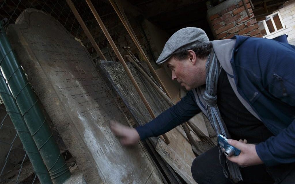 In this picture taken on Monday Oct. 26, 2015, Tomas Jelinek looks at a tombstone that was used as a doorstep to a hen house in efforts to restore a former Jewish cemetery in Prostejov, Czech Republic. (AP Photo/Petr Josek) In this picture taken on Monday Oct. 26, 2015, Tomas Jelinek looks at a tombstone that was used as a doorstep to a hen house in efforts to restore a former Jewish cemetery in Prostejov, Czech Republic. (AP Photo/Petr Josek)