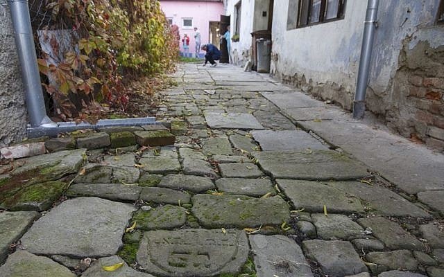 In this picture taken on Monday Oct. 26, 2015, Tomas Jelinek looks at pavement made of tombstones in efforts to restore a former Jewish cemetery in Prostejov, Czech Republic. (AP Photo/Petr Josek) In this picture taken on Monday Oct. 26, 2015, Tomas Jelinek looks at pavement made of tombstones in efforts to restore a former Jewish cemetery in Prostejov, Czech Republic. (AP Photo/Petr Josek)