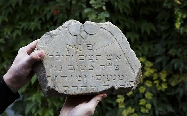 In this picture taken on Monday Oct. 26, 2015, Tomas Jelinek displays part of a tombstone in efforts to restore a former Jewish cemetery in Prostejov, Czech Republic. (AP Photo/Petr Josek) In this picture taken on Monday Oct. 26, 2015, Tomas Jelinek displays part of a tombstone in efforts to restore a former Jewish cemetery in Prostejov, Czech Republic. (AP Photo/Petr Josek)