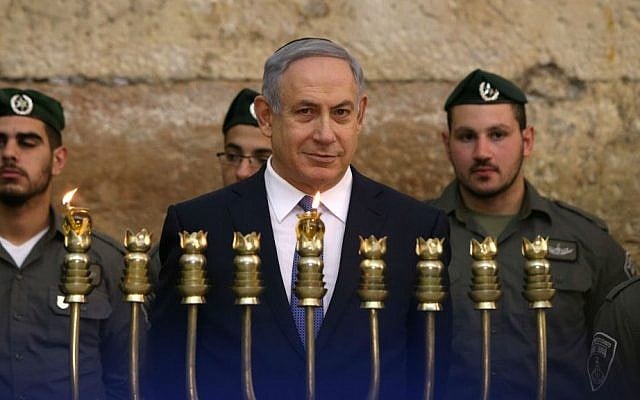 Prime Minister Benjamin Netanyahu lights the first candle of Hanukkah with Border Police officers at the Western Wall in Jerusalem, December 6, 2015. (Amit Shabi/Pool/Flash90) Prime Minister Benjamin Netanyahu lights the first candle of Hanukkah with Border Police officers at the Western Wall in Jerusalem, December 6, 2015. (Amit Shabi/Pool/Flash90)