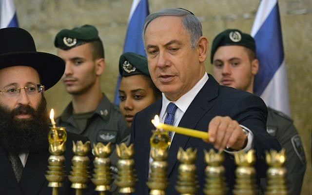 Prime Minister Benjamin Netanyahu lights the menorah on the first night of the Jewish holiday of Hanukkah at the Western Wall in Jerusalem Old City on December 6, 2015. (Kobi Gideon/GPO)