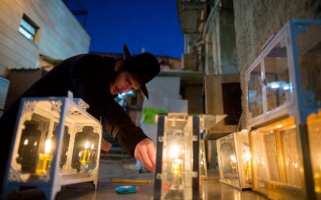 An ultra-Orthodox Jewish man lights candles for the Jewish holiday of Hanukkah in Jerusalem's Mea Shearim neighborhood on December 6, 2015. (Yonatan Sindel/Flash90)