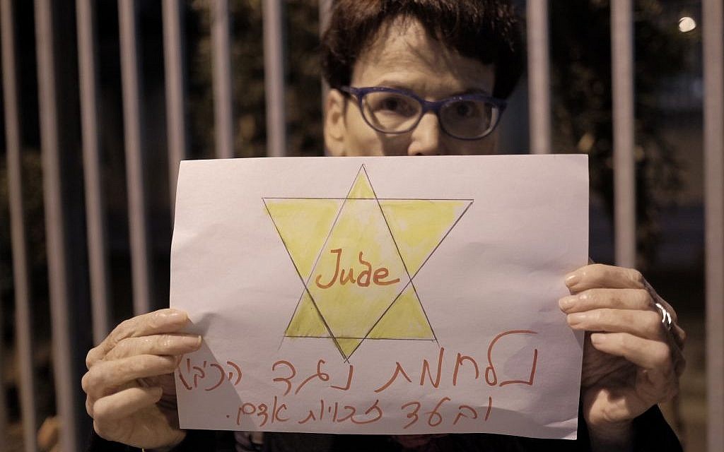 A Peace Now activists holding a sign reading "fighting against the occupation and for human rights" at a protest against the NGO bill in Tel Aviv on December 26, 2015. (Tomer Neuberg/FLASH90)