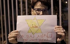 A Peace Now activists holding a sign reading "fighting against the occupation and for human rights" at a protest against the NGO bill in Tel Aviv on December 26, 2015. (Tomer Neuberg/FLASH90)