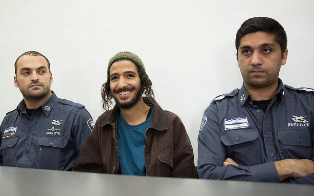 Yakir Ashbel (center), the groom from what came to be known as the 'hate wedding,' is brought to the Jerusalem Magistrate's Court on December 31, 2015 after being arrested on suspicion of racist incitement at his wedding celebration. (Flash90)