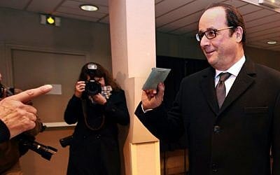 French President Francois Hollande holds his ballot for the second round of regional elections, in Tulle, central France, on December 13, 2015. (AP Photo/Bob Edme)