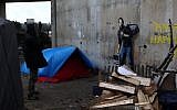 A painting by English graffiti artist Banksy is seen at the entrance of the Calais refugee camp in France, Saturday, Dec. 12, 2015. (AP Photo/Michel Spingler)