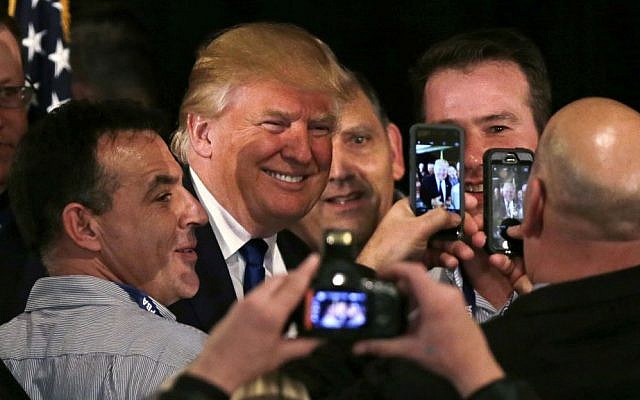 Republican presidential candidate Donald Trump smiles as he has his photograph taken with supporters after being endorsed at a regional police union meeting in Portsmouth, New Hampshire, Thursday, Dec. 10, 2015. (AP Photo/Charles Krupa)