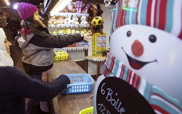 Syrian refugee Raghad Habashieh, right, plays a ball besides her sister Reem Habashieh, left, as they visit the Christmas market in Zwickau, eastern Germany on Dec. 8, 2015. (AP Photo/Jens Meyer)