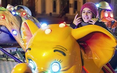 Syrian refugee Raghad Habashieh rides on a carousel at the Christmas market in Zwickau, eastern Germany on Dec. 8, 2015. (AP Photo/Jens Meyer)