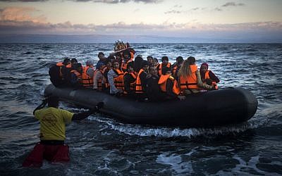 Refugees and migrants arrive on a dinghy from the Turkish coast to the Greek island of Lesbos, Friday, Dec. 18, 2015. (AP Photo/Santi Palacios)