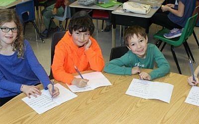 Students at Paul Penna Downtown Jewish Day School in Toronto, Canada write cards welcoming Syrian refugees, December 2015. (Courtesy)