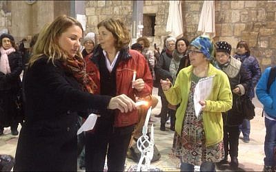 Member of Knesset Ksenia Svetlova lights a Hanukkah menorah at the Western Wall with Women of the Wall founding director Anat Hoffman (center), December 6, 2015. (Victoria Polak)