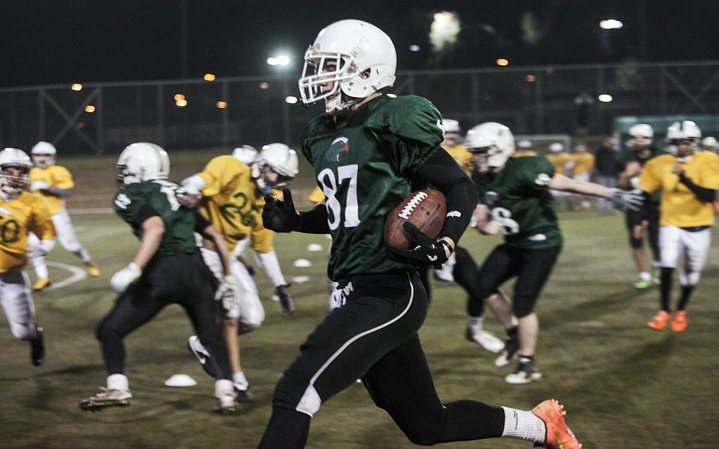 High school football team Kfar Saba Hawks,in green shirts, play against Mazkeret Batya Gorillas in Kfar Saba, Israel, December 10, 2015. (Photo by AP Photo/Dan Balilty)