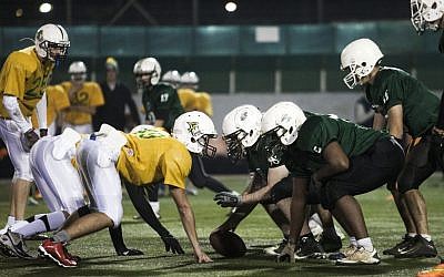 High school football team Kfar Saba Hawks, in green shirts, play against Mazkeret Batya Gorillas in Kfar Saba, December 10, 2015. (AP/Dan Balilty)