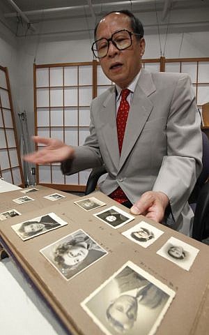 FILE - In this July 26, 2010 file photo, Akira Kitade displays a photo album that belonged to a former colleague of his at the Japan Tourist Bureau, Tatsuo Osako, during an interview in Tokyo. (Shizuo Kambayashi/AP) 