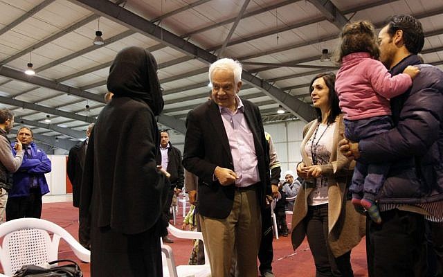 Canadian Minister of Immigration John McCallum, center, talks to a Syrian family soon to be resettled in Canada, Sunday, Dec. 20, 2015, at an airport in Amman, Jordan. (AP Photo/Sam McNeil)