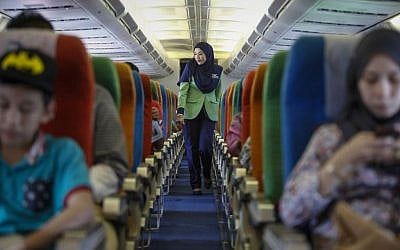In this Dec. 22, 2015, photo, a Rayani Air flight crew walks down the aisle on board before departure at Kuala Lumpur International Airport 2 in Sepang, Malaysia.(AP Photo/Joshua Paul)
