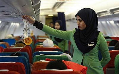 In this Dec. 22, 2015, photo, a Rayani Air flight crew demonstrates a safety brief before departure at the Sultan Ismail Petra Airport in Kelantan, Malaysia.  (AP Photo/Joshua Paul)