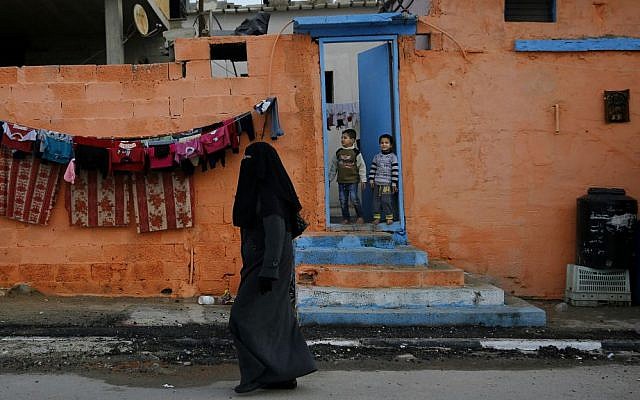 In this Tuesday, Dec. 15, 2015 photo, Palestinian children stand in a doorway of their home painted by artists in the Shati refugee camp in Gaza City. (AP Photo/Hatem Moussa)