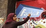 An art student from the University of Helwan paints the Facebook logo on a mural commemorating the revolution that overthrew Hosni Mubarak in the Zamalek neighborhood of Cairo, Egypt, March 30, 2011. (AP Photo/Manoocher Deghati, File)