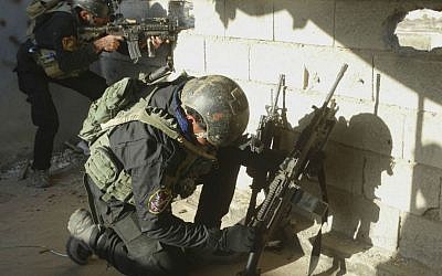 Iraqi security forces take combat positions at the front line with Islamic State fighters as Iraqi Army and allied Sunni volunteer tribal fighters supported by US-led coalition airstrikes tighten the siege of Ramadi, the capital of Iraq's Anbar province, Nov. 30, 2015. (AP Photo/Osama Sami)