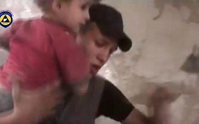 In this file image made from video posted online on Friday, Oct. 2, 2015, by Syrian Civil Defense, also known as the White Helmets, a volunteer search and rescue group, which has been verified and is consistent with other AP reporting, a paramedic rescues a child from the site of what witnesses said was a Russian airstrike in Douma, Syria. (Syria Civil Defense via AP video, File) In this file image made from video posted online on Friday, Oct. 2, 2015, by Syrian Civil Defense, also known as the White Helmets, a volunteer search and rescue group, which has been verified and is consistent with other AP reporting, a paramedic rescues a child from the site of what witnesses said was a Russian airstrike in Douma, Syria. (Syria Civil Defense via AP video, File)