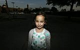 Sofia Yassini, 8, poses for a photo outside a mosque in Richardson, Texas, Friday, Dec. 11, 2015. (AP Photo/LM Otero)