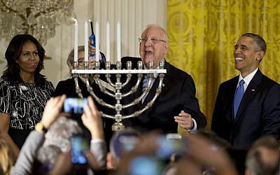 President Reuven Rivlin lights the menorah, joined by President Barack Obama, Michelle Obama, and Nechama Rivlin, during the first of two Hanukkah receptions the East Room of the White House in Washington, Wednesday, Dec. 9, 2015. (AP Photo/Carolyn Kaster)