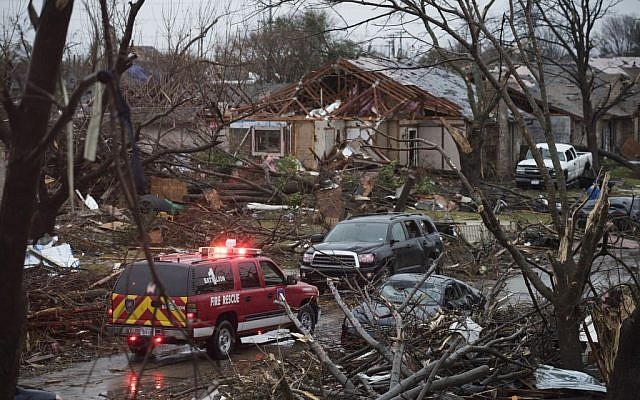 An emergency vehicle drives through a neighborhood in Rowlett, Texas, Sunday, December 27, 2015, the morning after it was struck by a tornado. (Photo by AP Photo/Rex C. Curry)