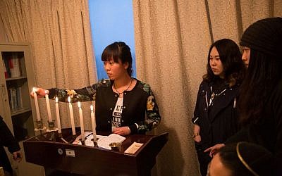 Members of the Kaifeng Chinese Jewish community light the menorah on the first night of Hanukkah, December 6, 2015. (Shavei Israel)