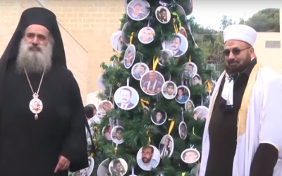 Palestinian religious leaders pose in front of a Christmas tree featuring pictures of Palestinian martyrs on December 1, 2015 (YouTube/Al-Quds Educational Television)