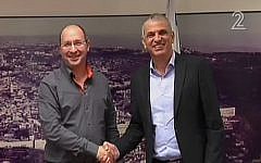 Histadrut labor federation leader Avi Nissenkorn (left) and Finance Minister Moshe Kahlon (right) shake hands during talks on December 21, 2015, aimed at avoiding a general strike over public-sector wages. (screen capture: Channel 2)