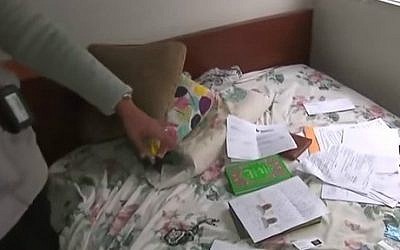 A CNN reporter pointing to an assortment of documents and Islamic religious items found at the California home of US citizen Syed Farook and his Pakistani wife Tashfeen Malik, December 5, 2015 (YouTube screen cap) 