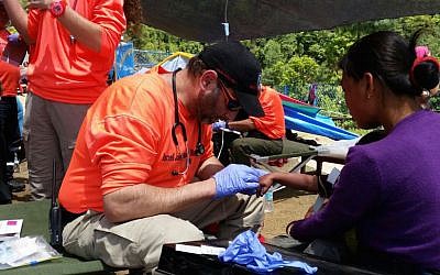 A United Hatzalah worker in Nepal prepares to open a Pocket BVM for field use during the devastating earthquake there in earlier this year (Courtesy)