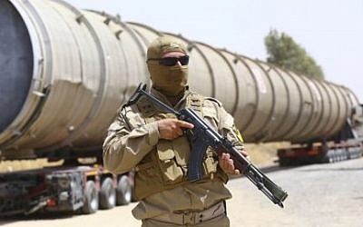 Kurdish security forces guard an oil refinery stolen by the Islamic State, before being brought on a truck to the Kalak refinery in the outskirts of Erbil, Iraq in 2014. (screen capture: YouTube)