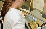 An expert in the US restoring one of the books rescued from the Iraqi Jewish community in Baghdad. (Courtesy: US National Archives and Records Administration)