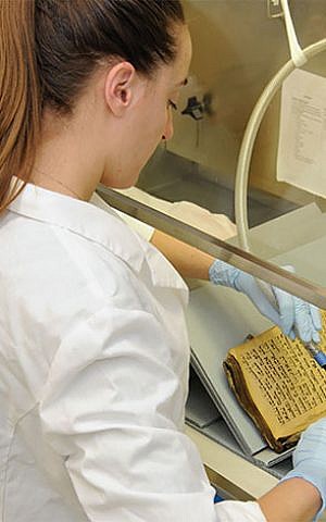 An expert in the US restoring one of the books rescued from the Iraqi Jewish community in Baghdad. (Courtesy: US National Archives and Records Administration)