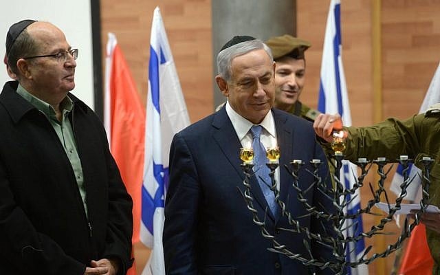 Benjamin Netanyahu, center, and Moshe Ya'alon, left, lighting candles with troops on December 7, 2015. (Amos Ben Gershom/ GPO)