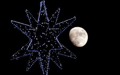 The moon rises behind the star of a Christmas Tree in central Rome on December 22, 2015. (AFP/TIZIANA FABI)
