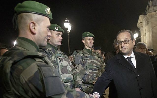 France's President Francois Hollande shakes hands with a foreign legionnaire as he visits the security control center at the Champs Elysees in Paris on New Year's Eve, December 31, 2015. (Michel Euler/Pool/AFP) France's President Francois Hollande shakes hands with a foreign legionnaire as he visits the security control center at the Champs Elysees in Paris on New Year's Eve, December 31, 2015. (Michel Euler/Pool/AFP)