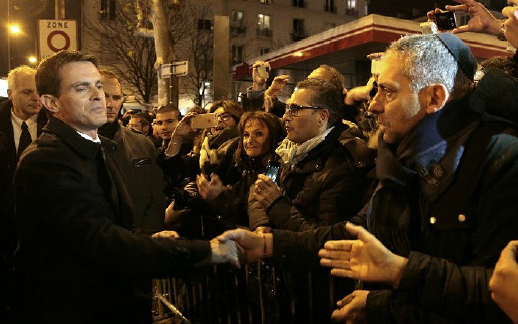 Manuel Valls (L) shakes hands with people on January 9, 2016 near the Hyper Cacher, a kosher supermarket, during a ceremony to pay tribute to the victims of the attack on the supermarket on January 9, 2015. (Jacques Demarthon/Pool/AFP) Manuel Valls (L) shakes hands with people on January 9, 2016 near the Hyper Cacher, a kosher supermarket, during a ceremony to pay tribute to the victims of the attack on the supermarket on January 9, 2015. (Jacques Demarthon/Pool/AFP)