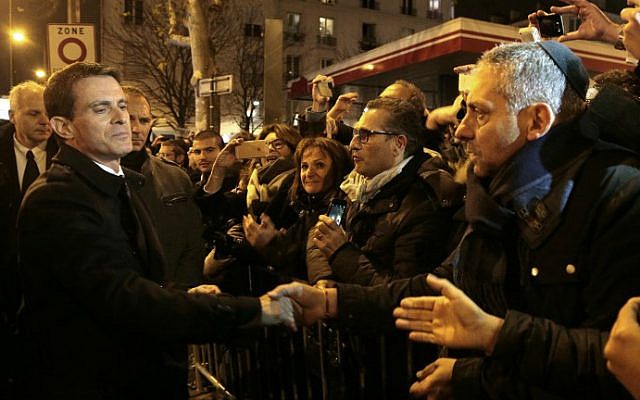 Manuel Valls (L) shakes hands with people on January 9, 2016 near the Hyper Cacher, a kosher supermarket, during a ceremony to pay tribute to the victims of the attack on the supermarket on January 9, 2015. (Jacques Demarthon/Pool/AFP) Manuel Valls (L) shakes hands with people on January 9, 2016 near the Hyper Cacher, a kosher supermarket, during a ceremony to pay tribute to the victims of the attack on the supermarket on January 9, 2015. (Jacques Demarthon/Pool/AFP)
