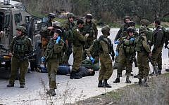 Israeli security forces gather around the body of a Palestinian man killed during a stabbing attack in the village of Assira al-Shamaliya near Nablus, in the West Bank, on January 14, 2016.  (AFP/JAAFAR ASHTIYEH)
